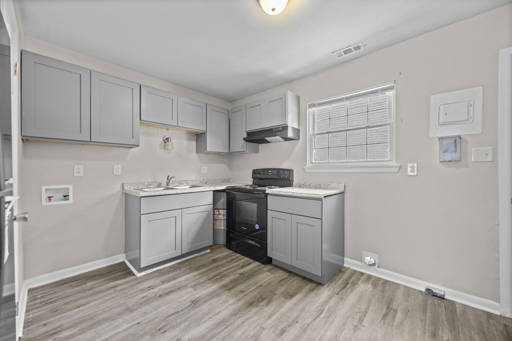 A kitchen with a black dishwasher and a white fridge.