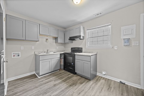 A kitchen with a black dishwasher and a white fridge.