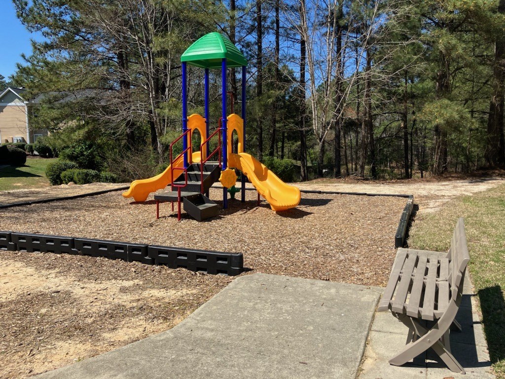 a playground with slides and a bench in a park