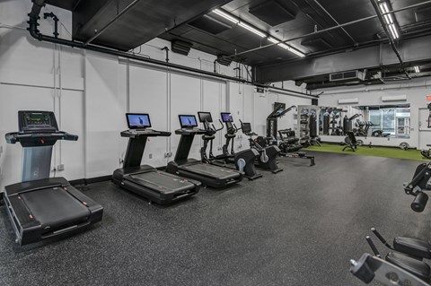 A gym with treadmills and other exercise equipment.