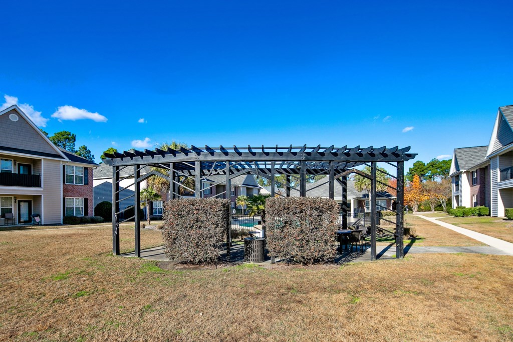 a patio with a table and chairs under a pergola