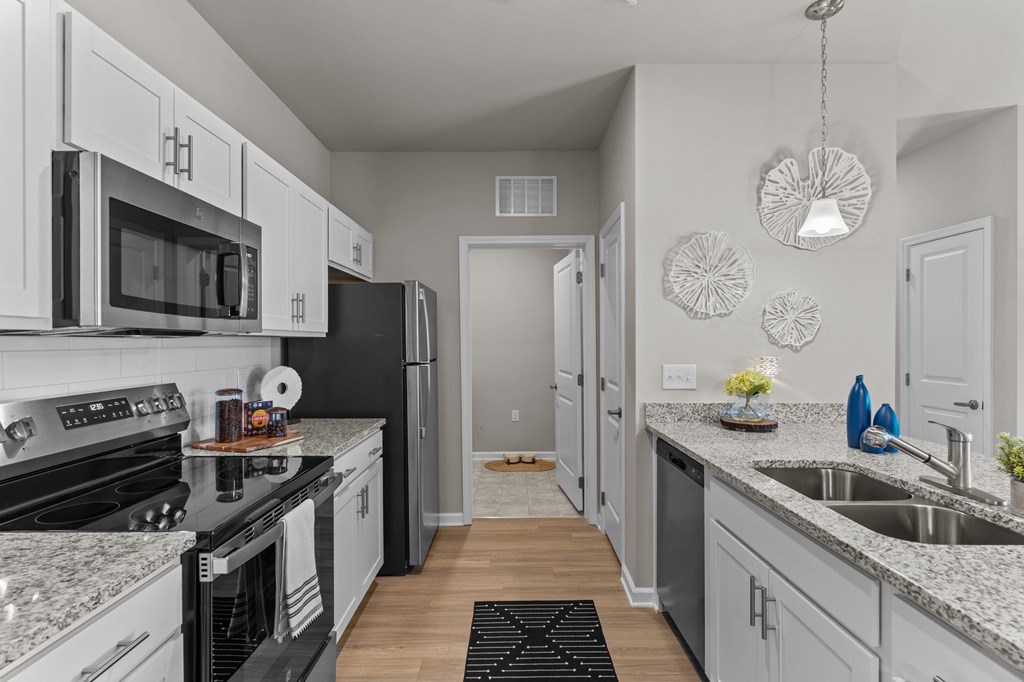 A kitchen with white cabinets and black appliances.