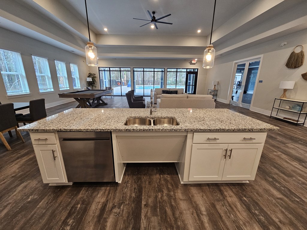 A modern kitchen with a large island and a ceiling fan.
