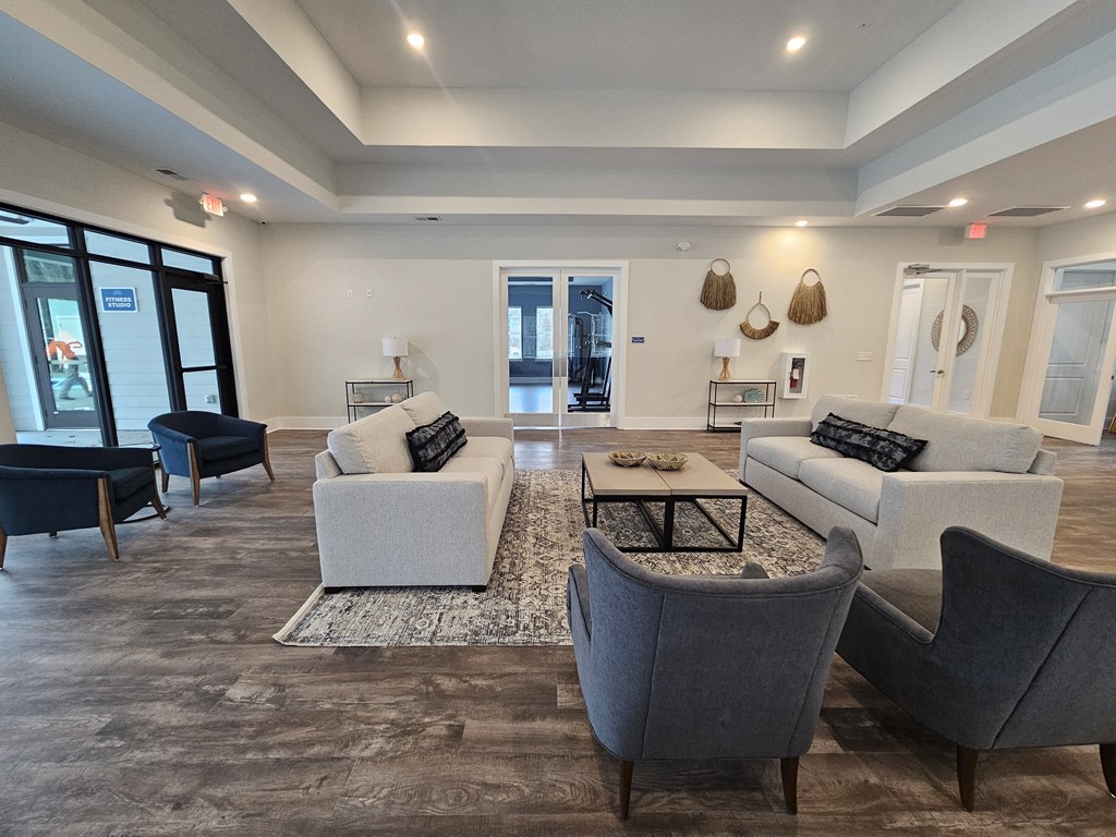 A spacious living room with grey and white furniture.