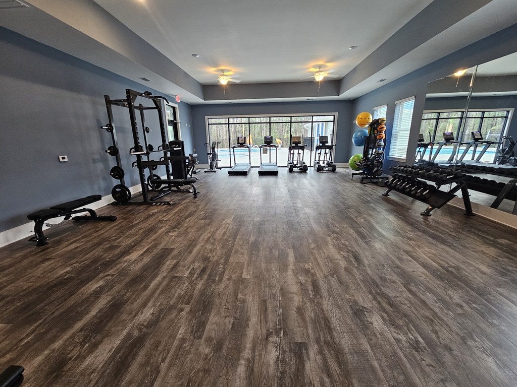 A gym with a variety of equipment including treadmills, weights, and exercise machines.