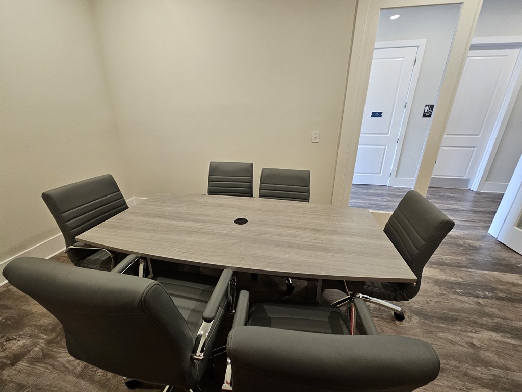 A conference room with a table and chairs.
