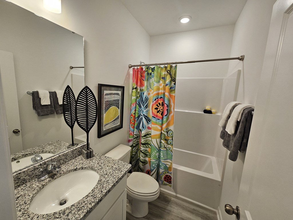A bathroom with a sink, toilet, and shower.