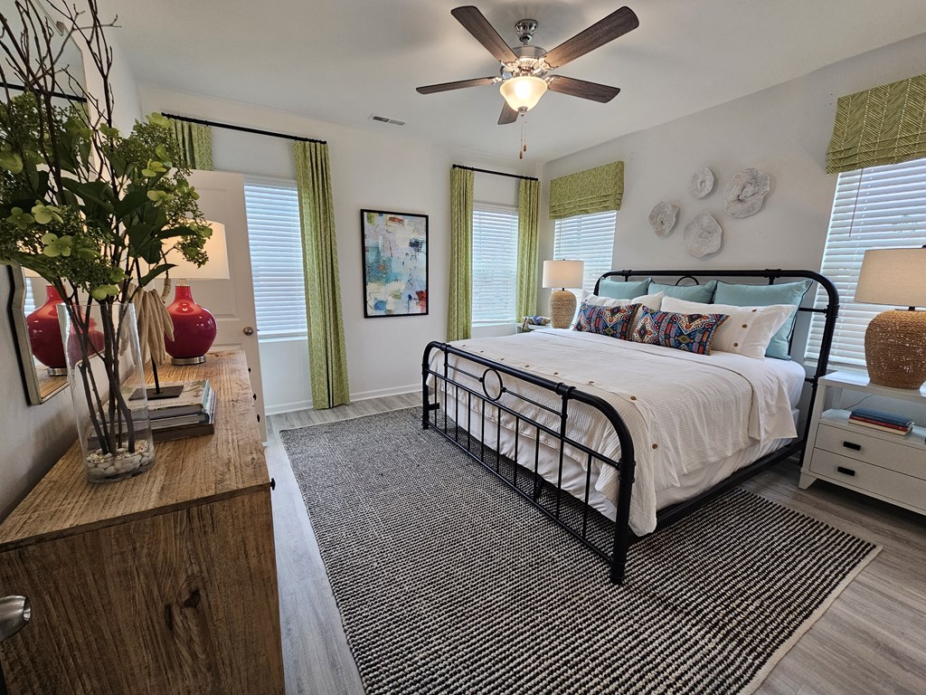 A bedroom with a bed, nightstand, and a ceiling fan.