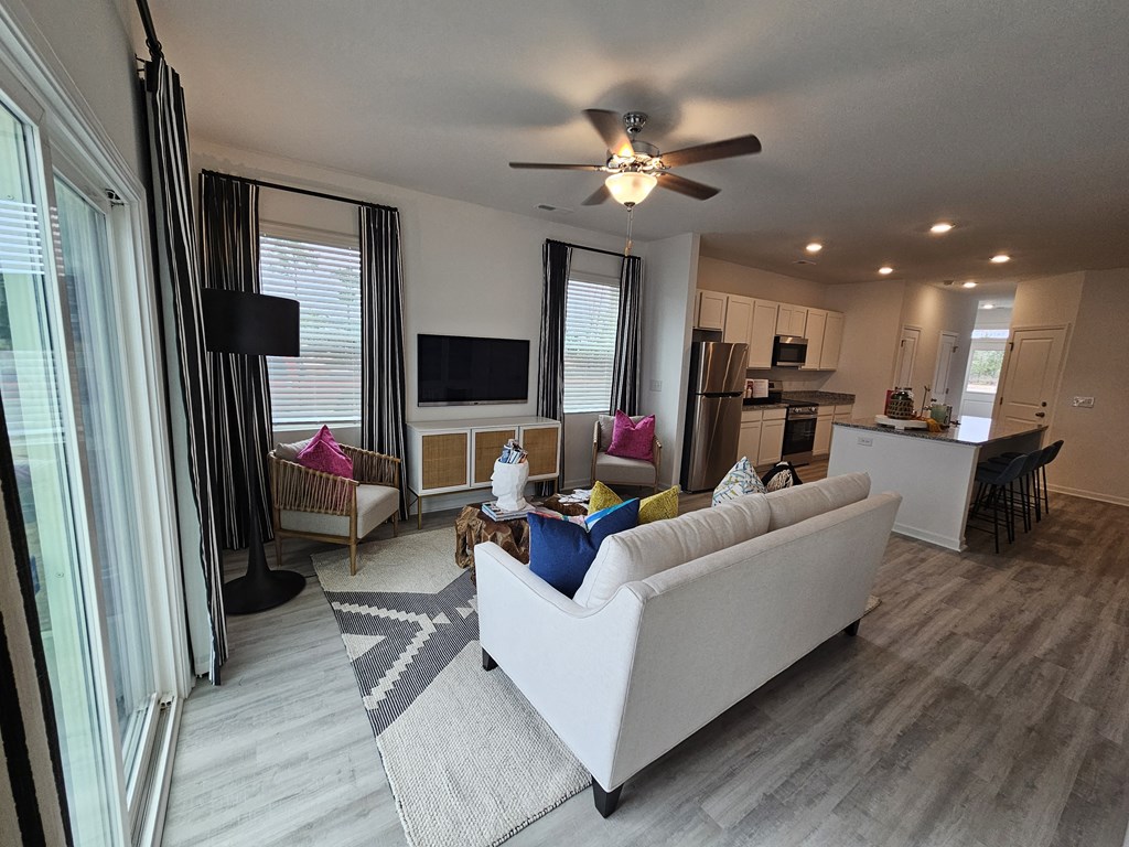 A living room with a white couch and a ceiling fan.