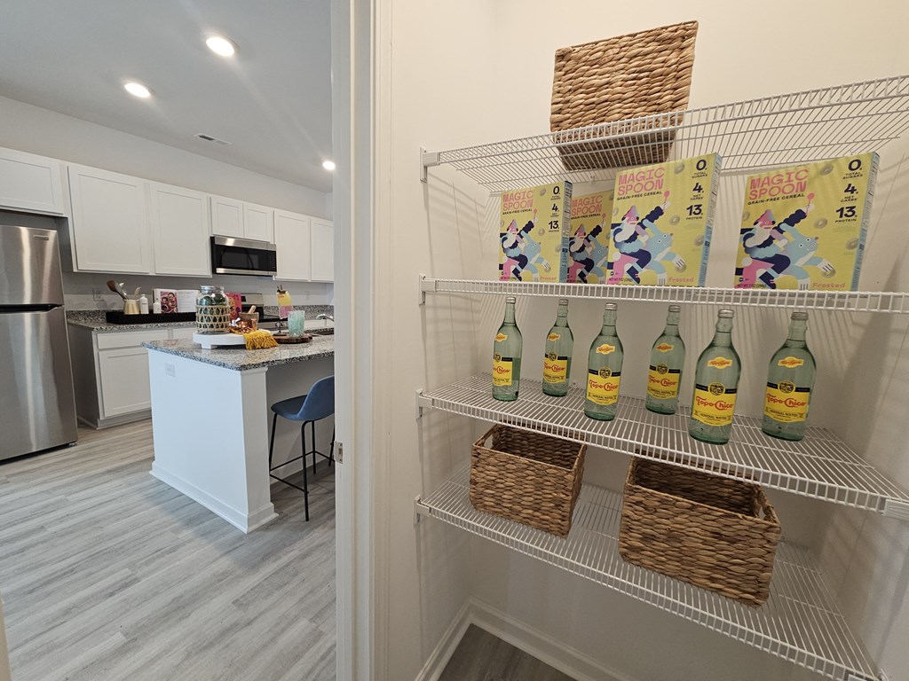 A kitchen with a refrigerator, microwave, and a bar area.