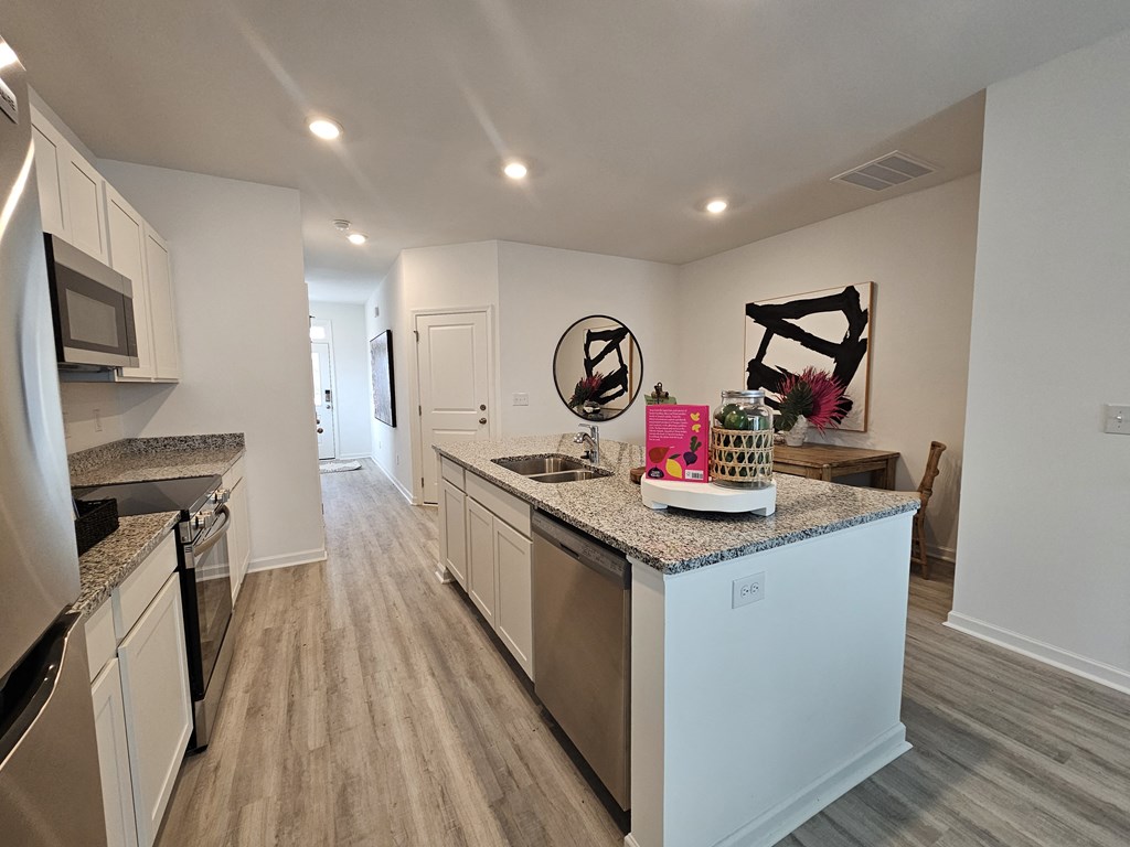 A kitchen with a granite countertop and stainless steel appliances.