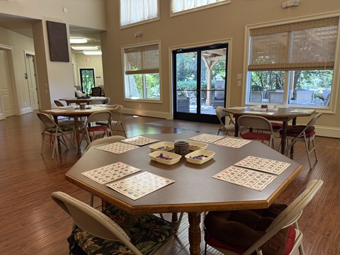 A dining room with a large table set for a game of dominoes.