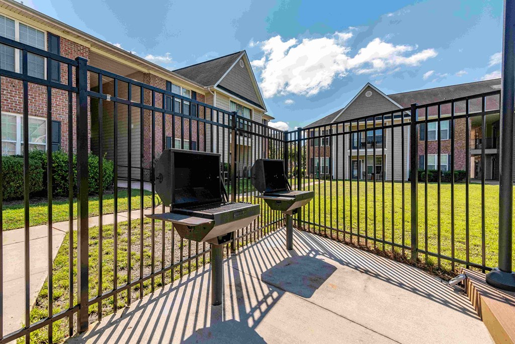 a patio with a laptop computer on a table in front of a fence