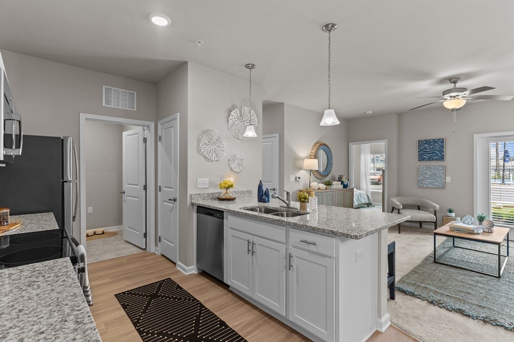A kitchen with a refrigerator, sink, and cabinets.