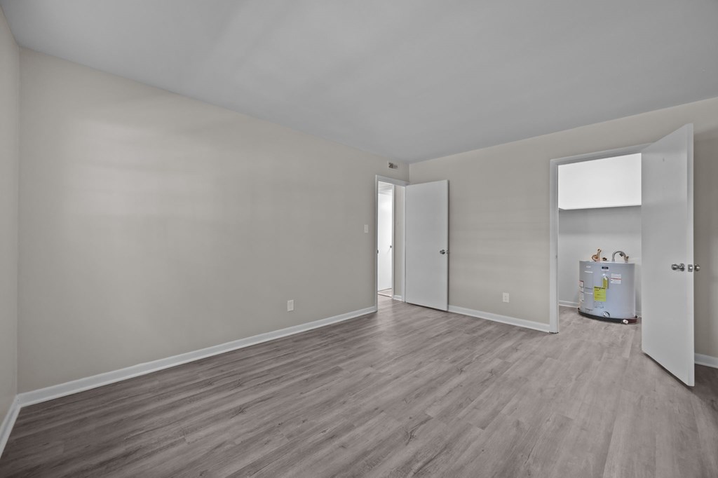 A room with wood flooring and white walls.