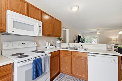 A white stove and oven in a kitchen with wooden cabinets.