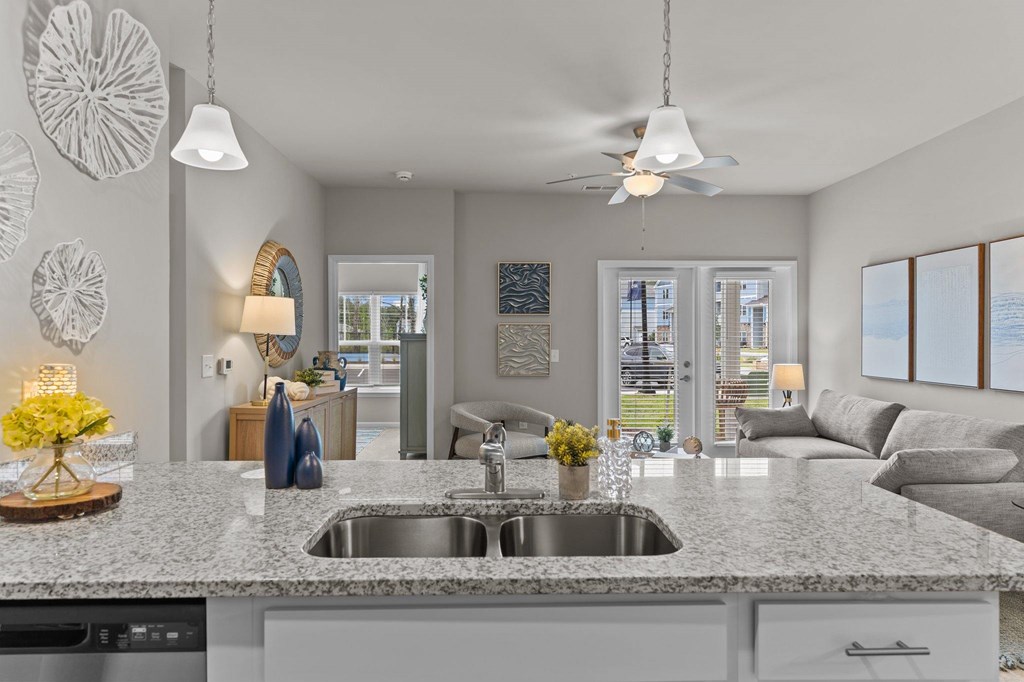 A modern kitchen with a granite countertop and a large window.