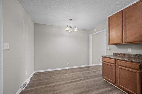 A room with wooden floors and a brown cabinetry.