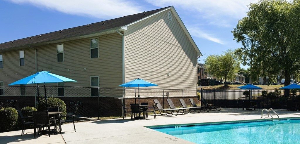 A pool area with a building in the background.