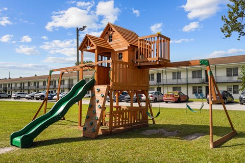 A wooden playground structure with a green slide.