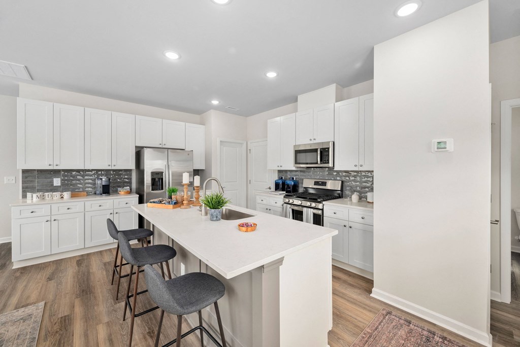 a large kitchen with white cabinets and a white counter top