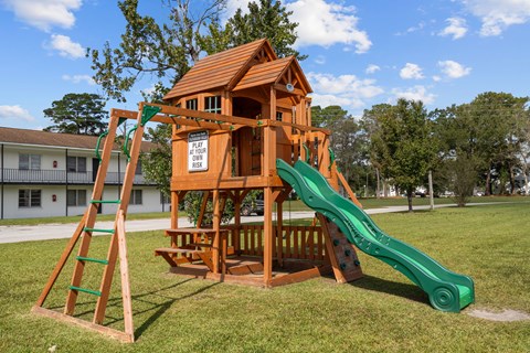 A wooden playground structure with a green slide.