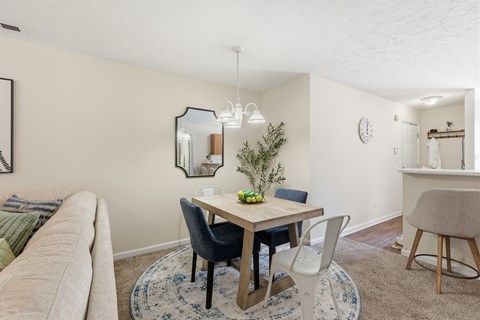 A dining room with a table and chairs.
