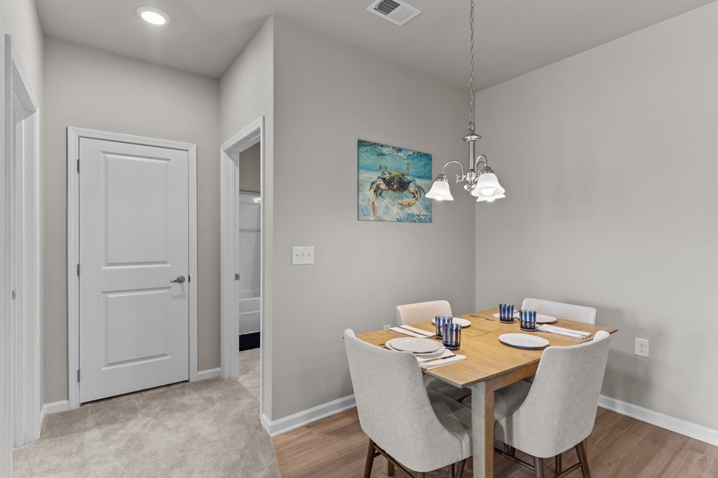 A dining room with a wooden table and chairs.
