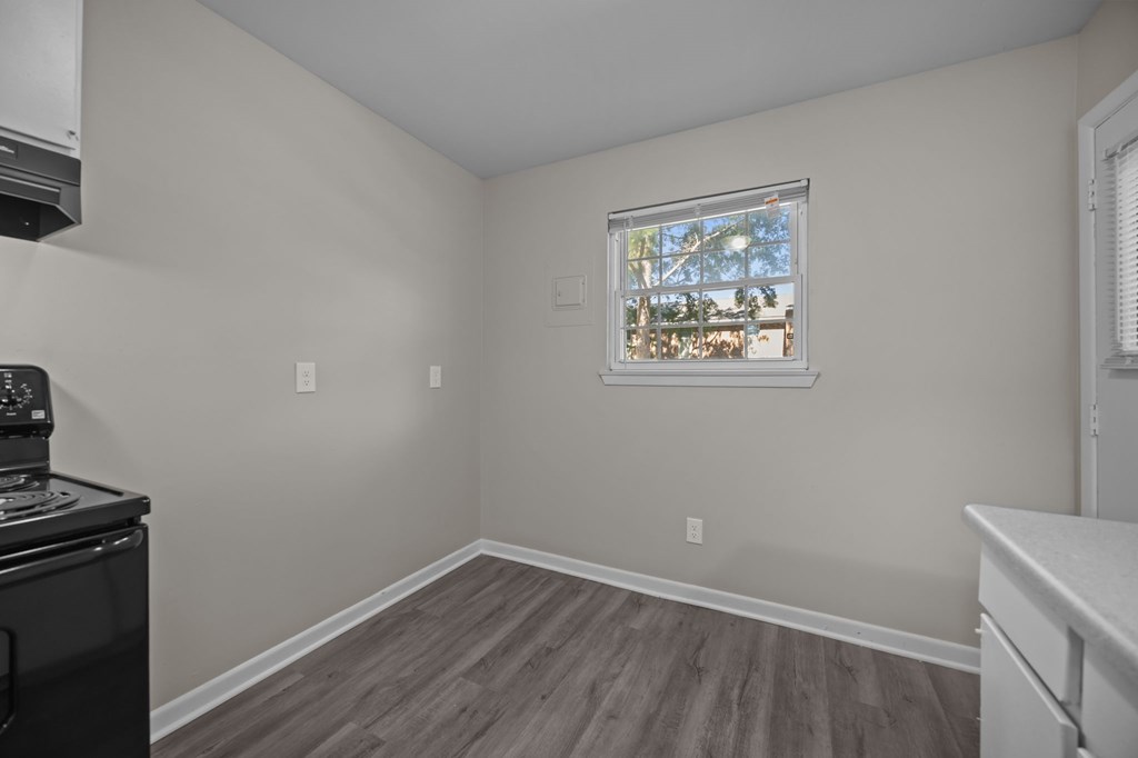 A kitchen with a window overlooking a tree.