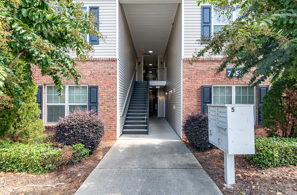 an exterior view of a brick building with stairs and a sidewalk