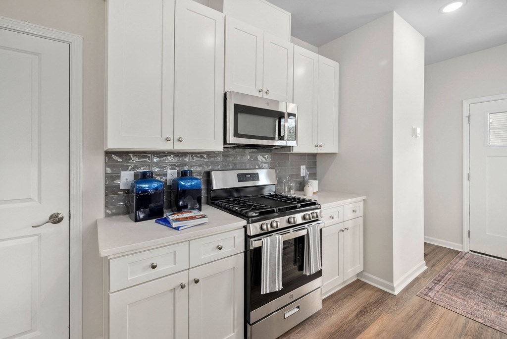a white kitchen with stainless steel appliances and white cabinets