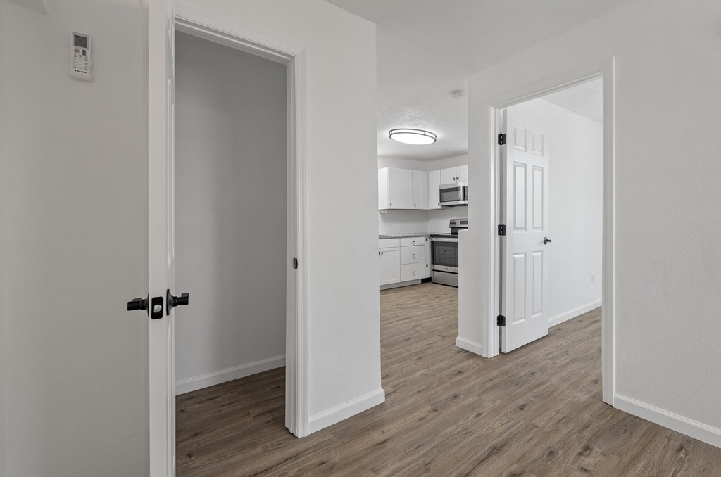 a bedroom and a living room with a door open to a kitchen