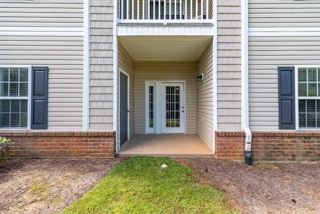 the entrance to a white house with blue doors