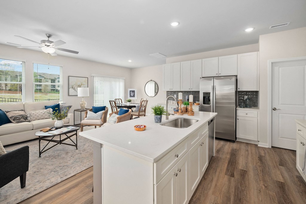 a kitchen with an island and a living room with a refrigerator