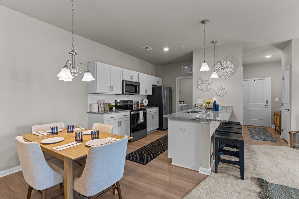 A modern kitchen with a dining table set for two.