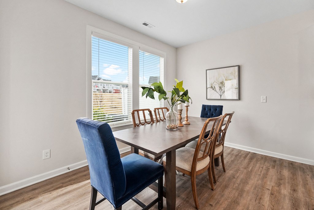 a dining room with a wooden table and chairs