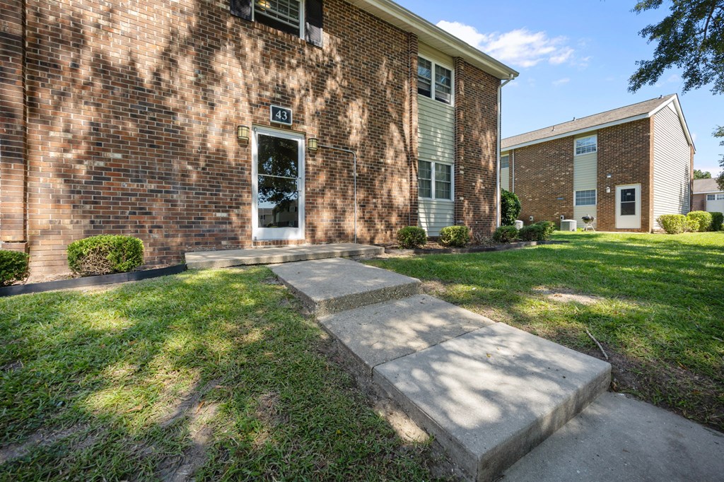 A brick building with a white door and windows.