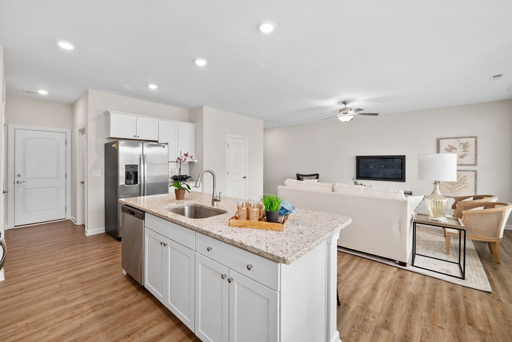 a white kitchen with a counter top and a sink