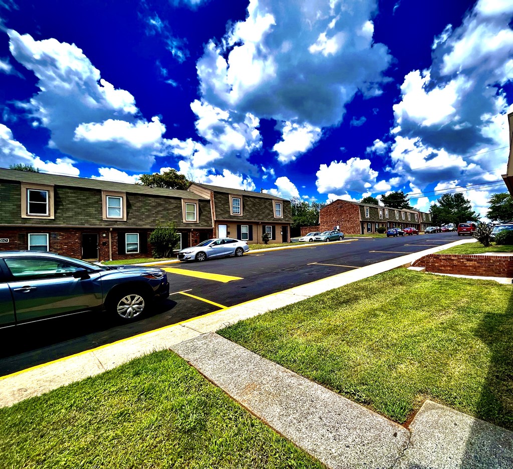 a city street with cars parked in front of apartment buildings