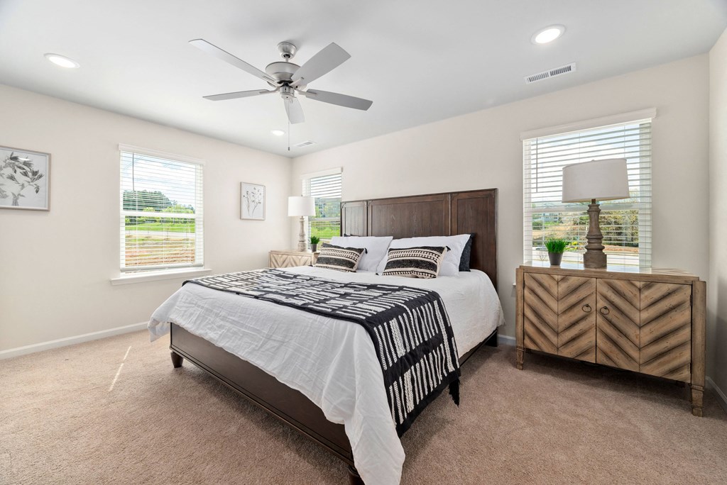 a bedroom with a bed and a ceiling fan