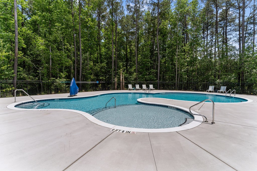 A person is standing at the edge of a swimming pool.