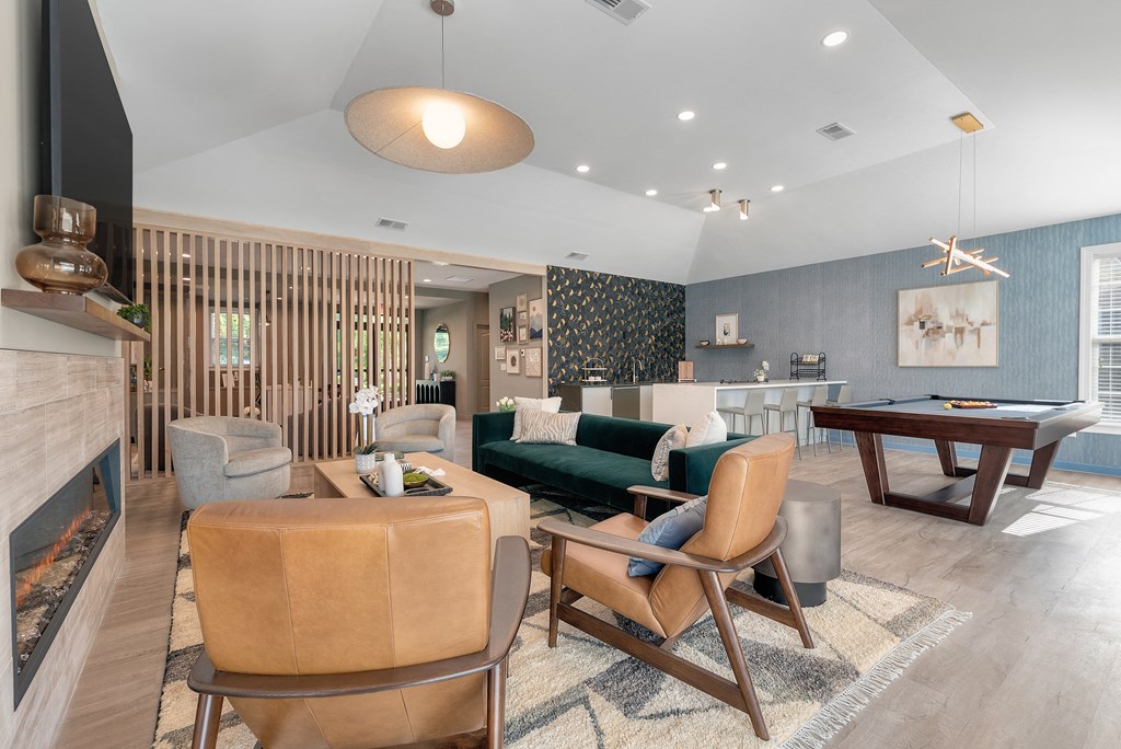a living room with a pool table and chairs