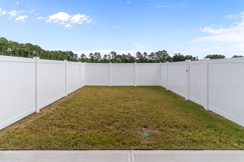 A white fenced yard with a green lawn.