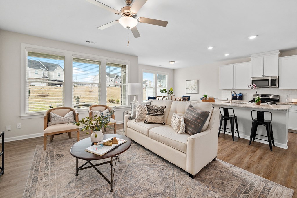 a living room with a couch and a table in front of a kitchen