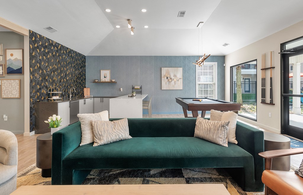 a living room with a green couch and a pool table