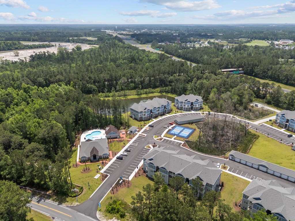 A bird's eye view of a residential area with a roundabout and houses.