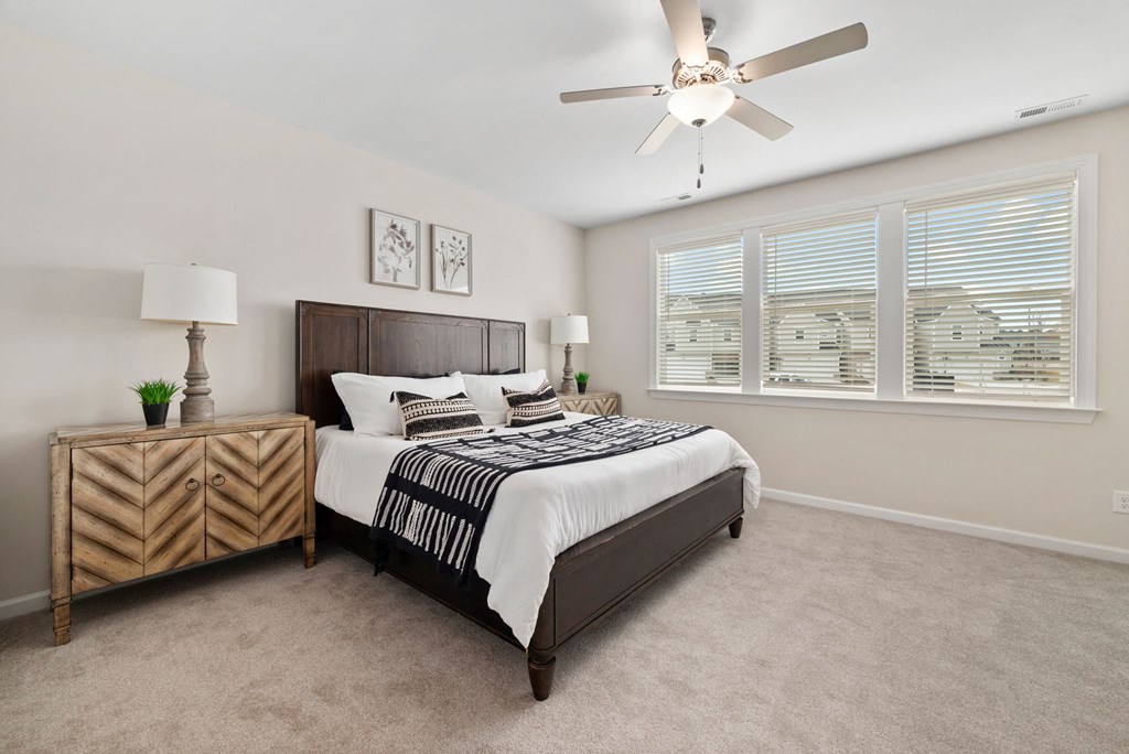 a bedroom with a bed and a ceiling fan