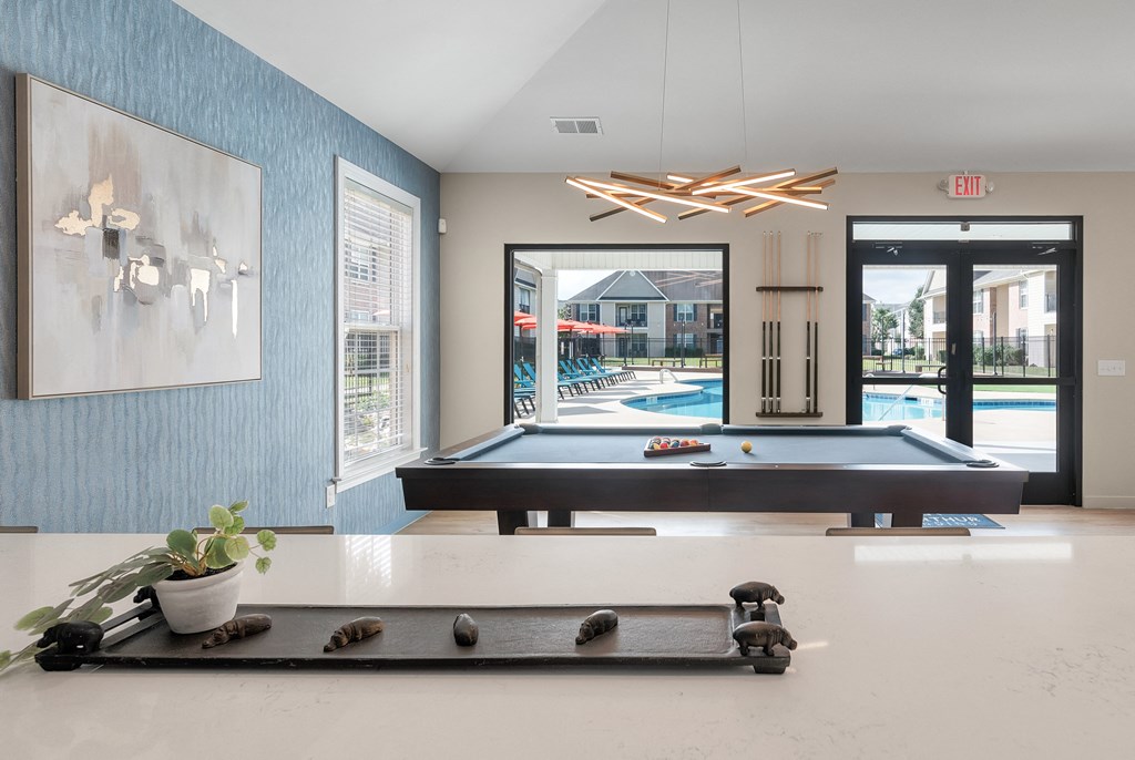 a pool table in a room with a view of a swimming pool