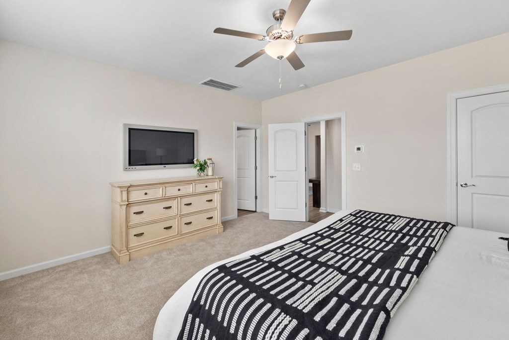 a master bedroom with a large bed and a tv