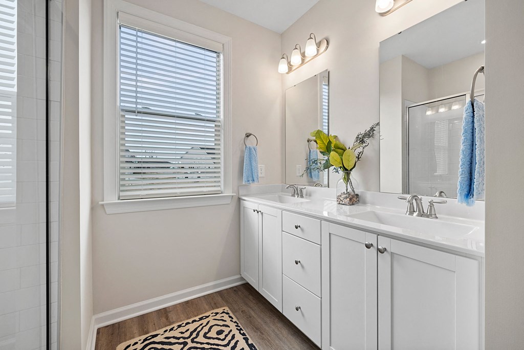 a bathroom with white cabinets and a sink and a mirror